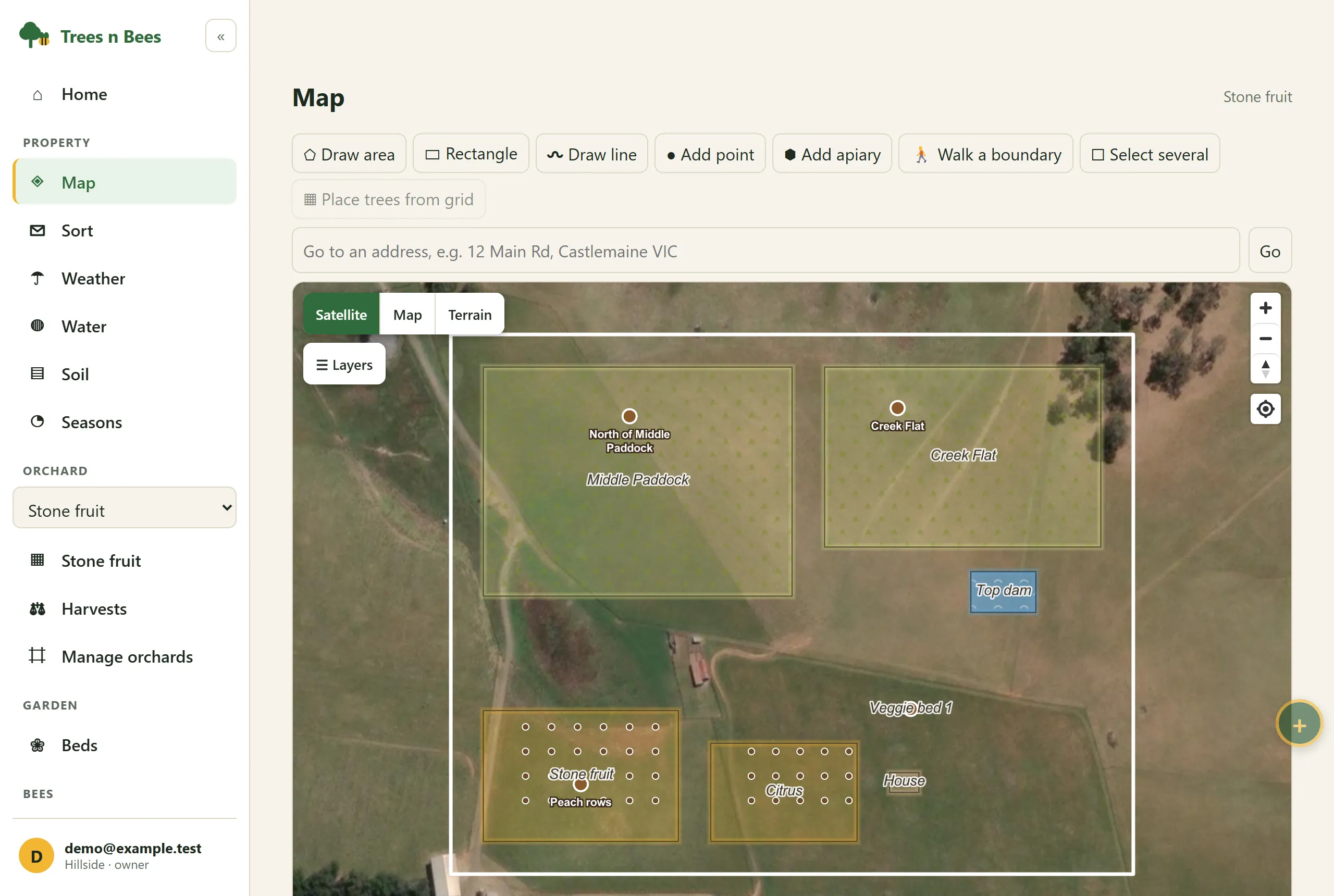 Property map over satellite imagery with paddocks, two orchards, a dam and a garden bed, and brown pins at the soil sample spots labelled North of Middle Paddock, Creek Flat and Peach rows